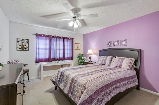 carpeted bedroom featuring ceiling fan and a textured ceiling