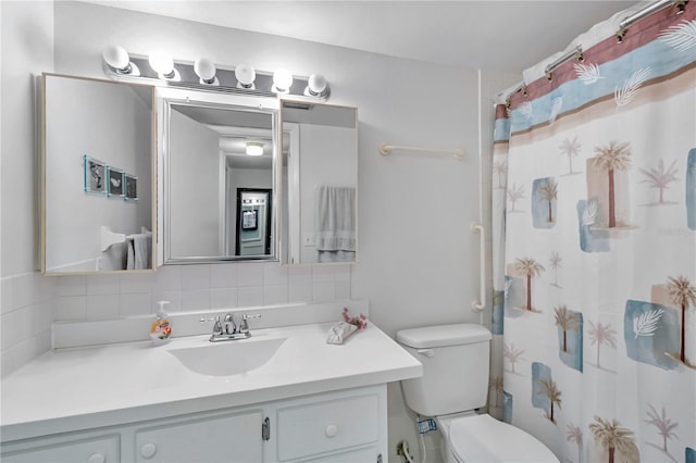 bathroom with curtained shower, vanity, and toilet