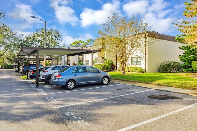 view of vehicle parking with a yard and a carport