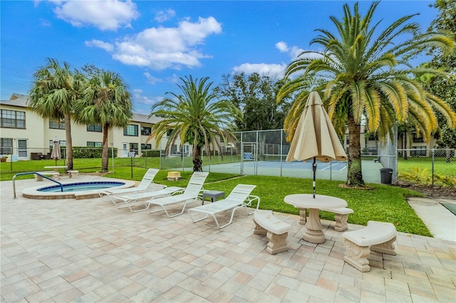 view of community featuring a yard and tennis court