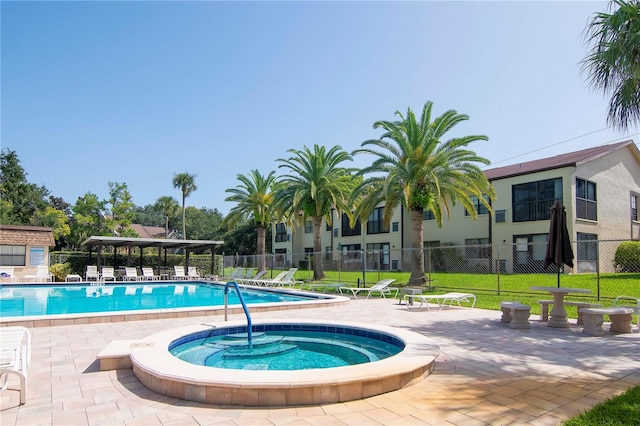 view of swimming pool featuring a community hot tub and a patio