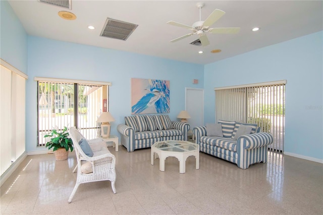 living room with ceiling fan and a high ceiling