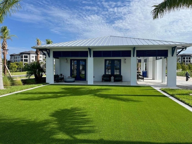 back of property featuring a lawn and french doors