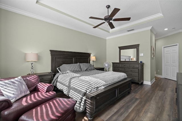 bedroom featuring ornamental molding, ceiling fan, dark hardwood / wood-style flooring, and a tray ceiling