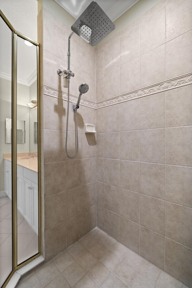 bathroom featuring ornamental molding, a tile shower, and vanity