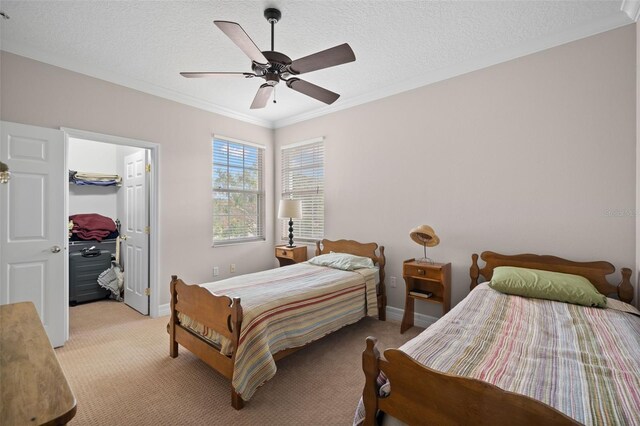 bedroom featuring crown molding, light colored carpet, and a textured ceiling