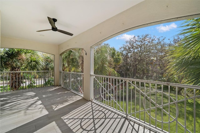 unfurnished sunroom with ceiling fan