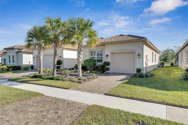 mediterranean / spanish-style house featuring a front lawn and a garage