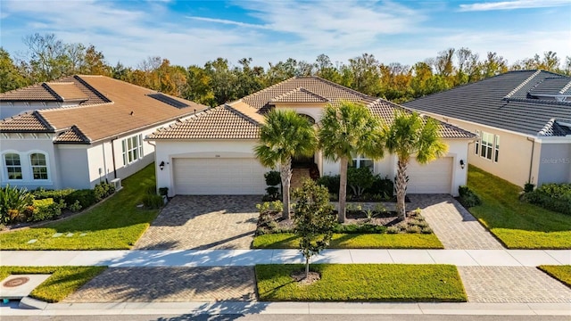 mediterranean / spanish home with a front lawn and a garage