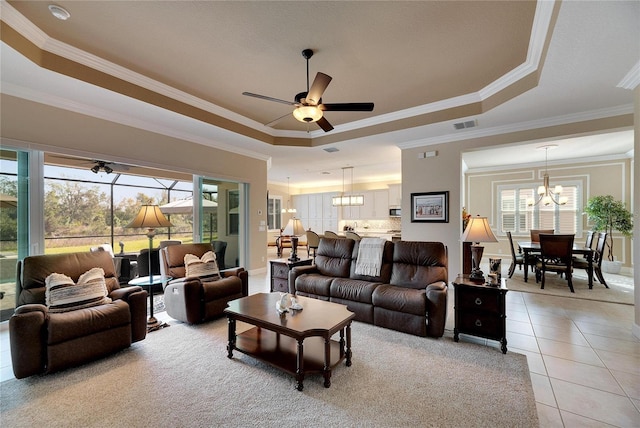 tiled living room with plenty of natural light, ornamental molding, and a tray ceiling