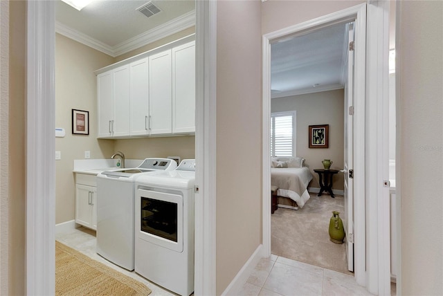 clothes washing area with cabinets, light carpet, sink, crown molding, and washing machine and dryer