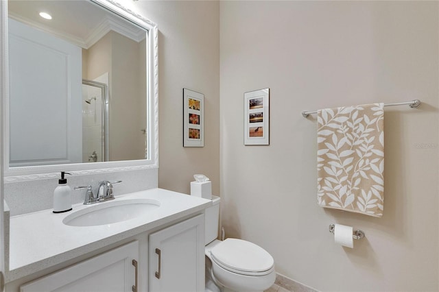 bathroom with vanity, toilet, a shower with door, and crown molding