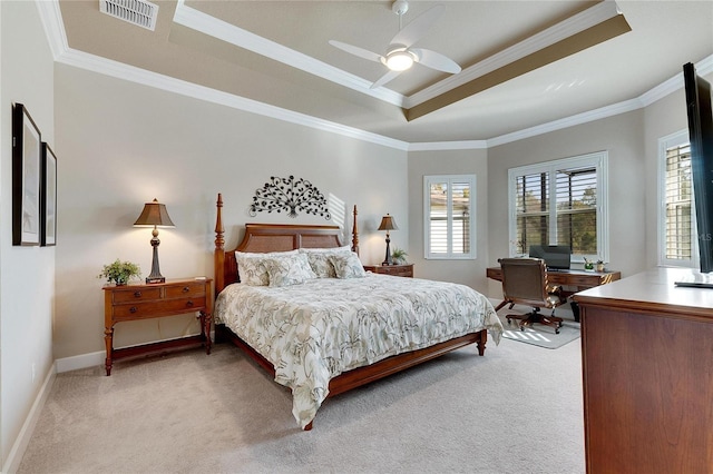 carpeted bedroom with a tray ceiling, ceiling fan, and ornamental molding