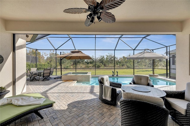 view of patio / terrace with a lanai, ceiling fan, and a swimming pool with hot tub