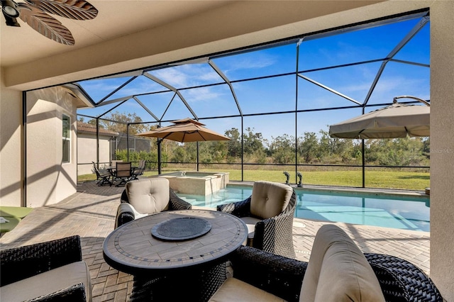 view of patio with a lanai, ceiling fan, and a pool with hot tub