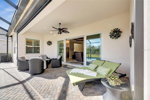 view of patio / terrace featuring glass enclosure, ceiling fan, and outdoor lounge area