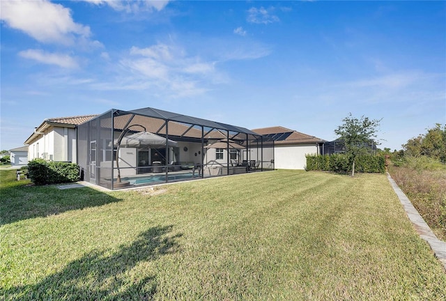 rear view of property with a lanai and a lawn