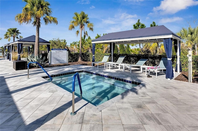 view of swimming pool with a gazebo, a patio, and a hot tub