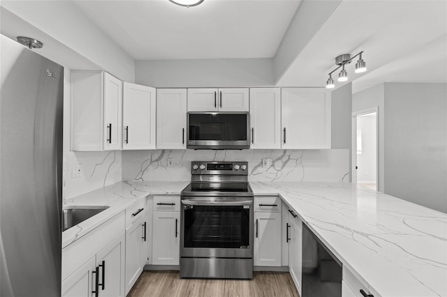 kitchen featuring white cabinets, backsplash, and appliances with stainless steel finishes