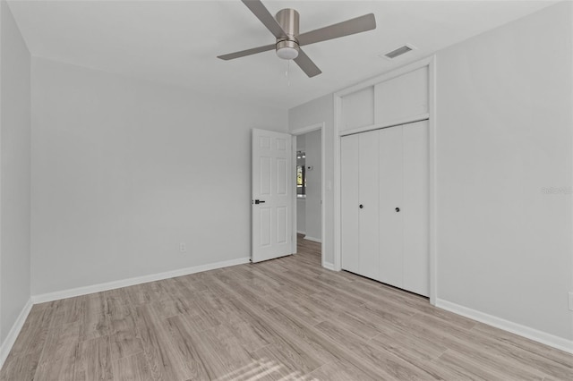 unfurnished bedroom with ceiling fan, a closet, and light wood-type flooring