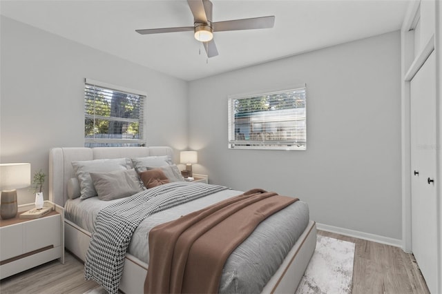 bedroom with ceiling fan, light hardwood / wood-style floors, and a closet