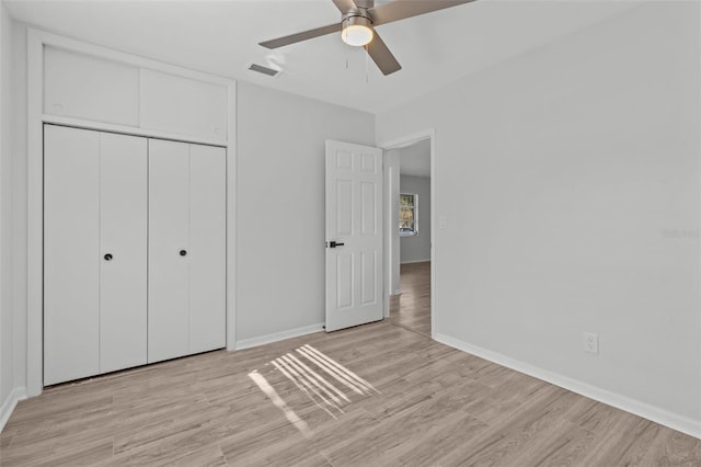 unfurnished bedroom with ceiling fan, a closet, and light wood-type flooring