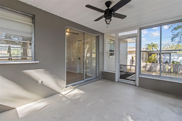 unfurnished sunroom with a wealth of natural light and ceiling fan