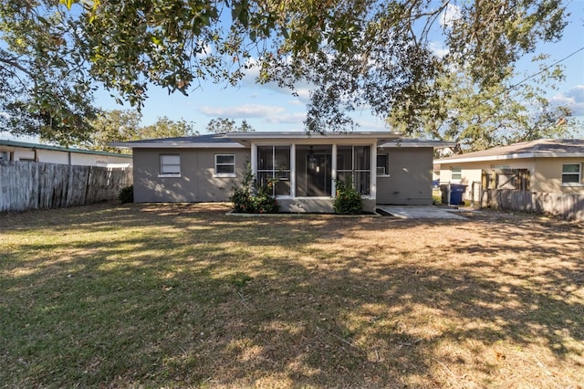 rear view of house with a yard and a sunroom