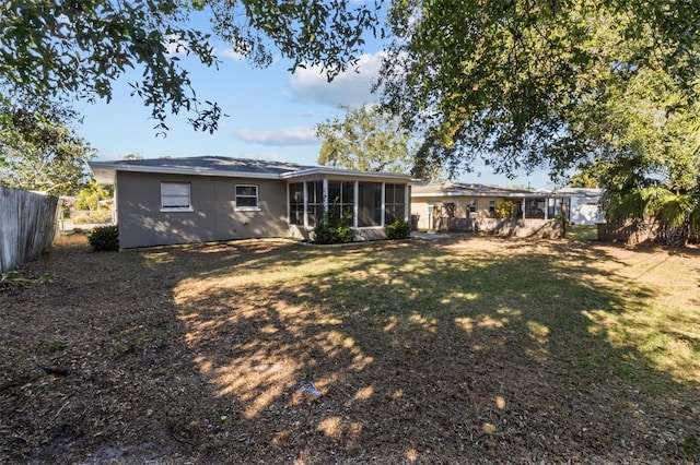 rear view of property with a yard and a sunroom