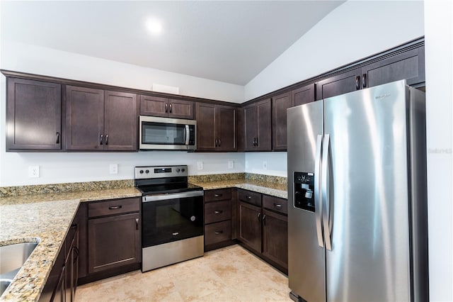 449 Grant Blvd, Lehigh Acres, FL 33974 - kitchen featuring appliances with stainless steel finishes, dark brown cabinetry, light stone countertops, lofted ceiling, and a sink