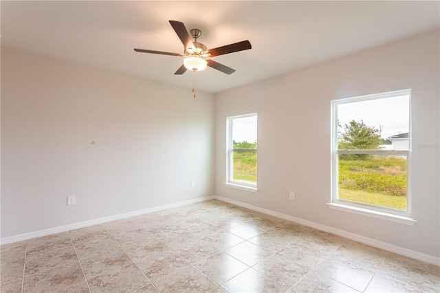 tiled empty room featuring ceiling fan