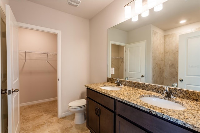 449 Grant Blvd, Lehigh Acres, FL 33974 - full bathroom featuring double vanity, a walk in closet, toilet, and baseboards