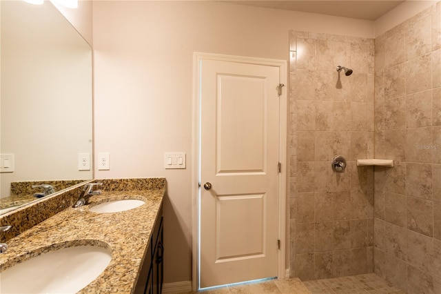 bathroom featuring a tile shower and vanity