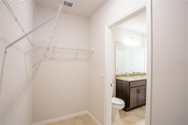 spacious closet featuring light tile patterned flooring and sink