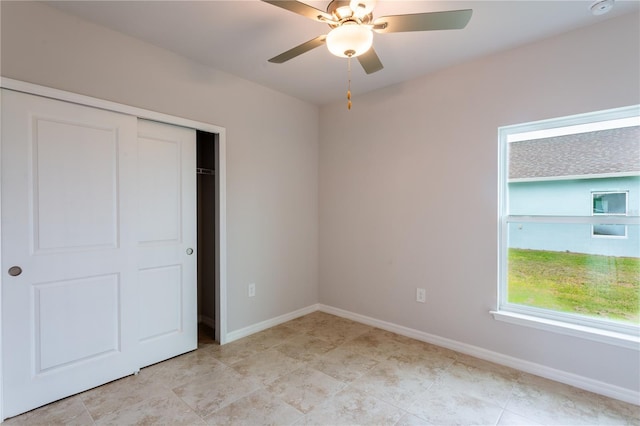 unfurnished bedroom featuring ceiling fan and a closet