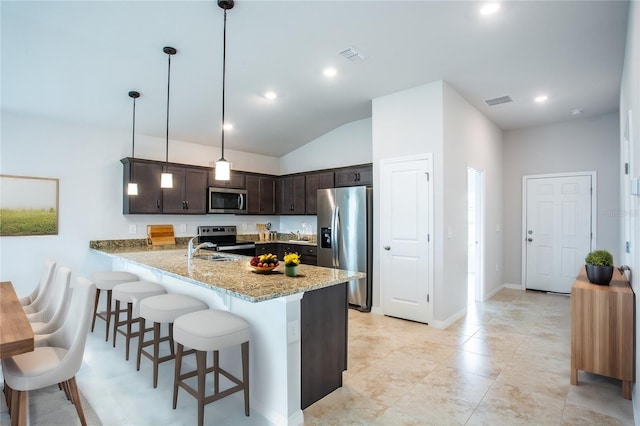 kitchen featuring kitchen peninsula, light stone countertops, dark brown cabinetry, stainless steel appliances, and hanging light fixtures