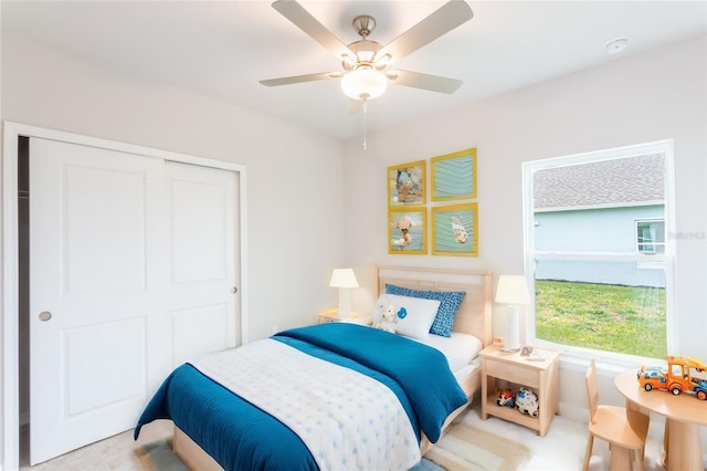 tiled bedroom featuring ceiling fan and a closet