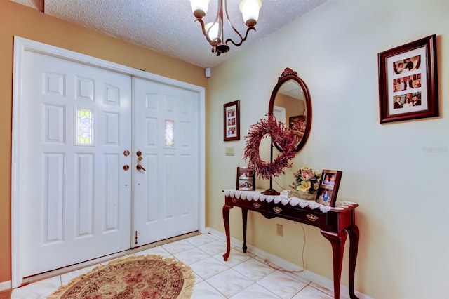 entrance foyer with light tile patterned floors, a textured ceiling, and an inviting chandelier