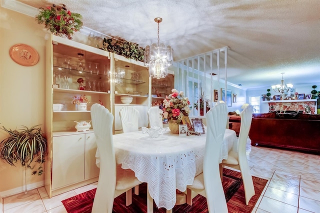 tiled dining room with a chandelier, a textured ceiling, and ornamental molding