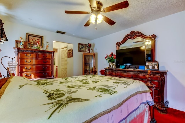 carpeted bedroom with ceiling fan, a textured ceiling, and a closet