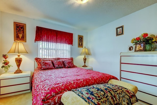 bedroom with light carpet and a textured ceiling