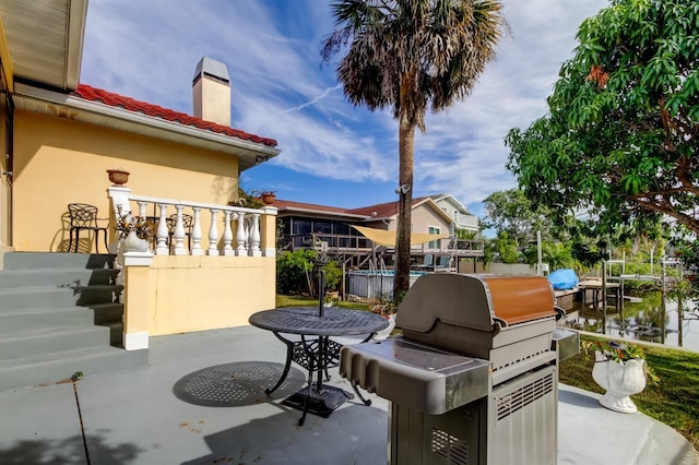 view of patio / terrace with a water view and area for grilling