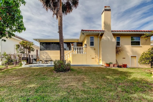 rear view of house featuring a patio and a lawn