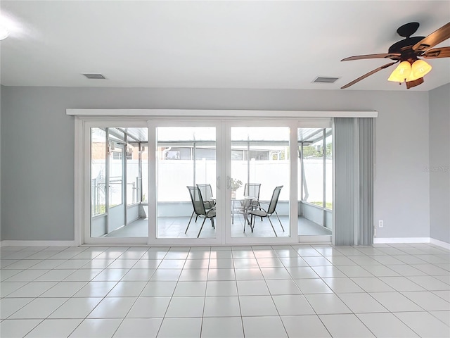 tiled empty room with ceiling fan and a healthy amount of sunlight