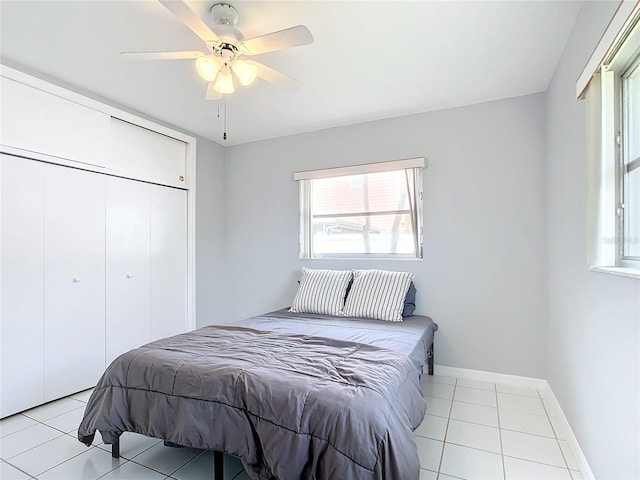 bedroom with ceiling fan, a closet, and light tile patterned floors