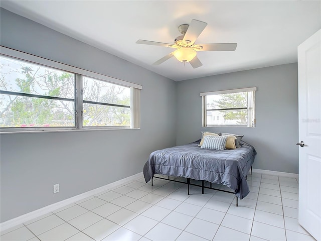 bedroom featuring multiple windows, light tile patterned floors, and ceiling fan