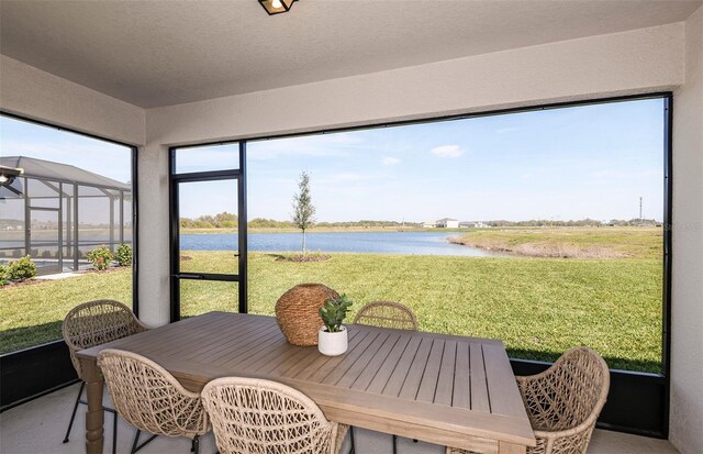 sunroom featuring a water view