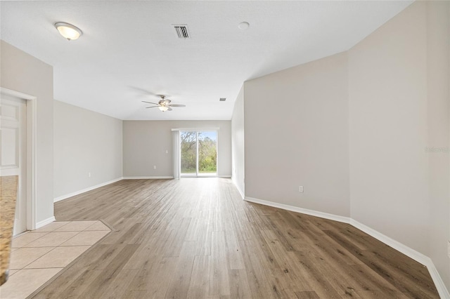 empty room with ceiling fan and light wood-type flooring