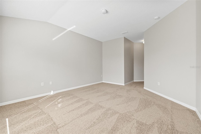 unfurnished room with carpet flooring and lofted ceiling