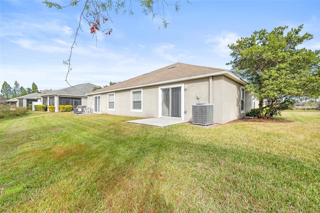 rear view of property featuring a yard, a patio, and cooling unit